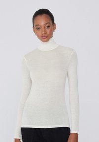 Weißes Rollkragenoberteil aus leichtem, transparentem Stoff. Enganliegendes Design mit langen Ärmeln und einer subtilen, strukturierten Oberfläche. Minimalistischer Stil.