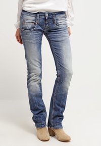 Blå denimjeans med rak passform, med blekning, subtila slitningar och bronsdetaljer på fickor och midjeband.