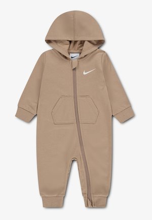 Combinaison beige pour bébé avec capuche, fermeture éclair à l'avant, manches longues, poche devant, poignets et chevilles côtelés, et logo Nike blanc sur la poitrine.