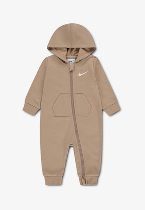 Combinaison beige pour bébé avec capuche, fermeture éclair à l'avant, manches longues, poche devant, poignets et chevilles côtelés, et logo Nike blanc sur la poitrine.