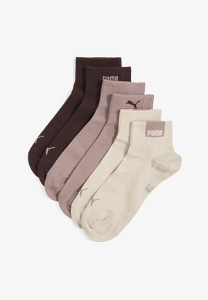 Pięć par skarpetek Puma do kostki w odcieniach brązu, beżu i kremu, każda z logo Puma na ściągaczu przy kostce.