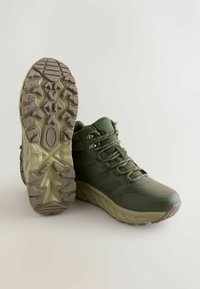 Oliwkowe buty trekkingowe z teksturowanej siateczki i gumowymi akcentami. ObFitna gumowa podeszwa z głębokim bieżnikiem dla lepszej przyczepności. Zapięcie na sznurówki.