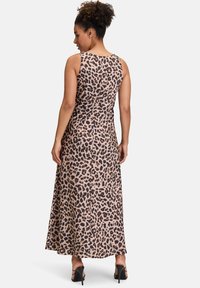 Sukienka maxi w leopardzie, bez rękawów, wykonana z gładkiego materiału, posiada dopasowaną sylwetkę z rozkloszowanym dołem, długość do kostek. Czarne szpilki.