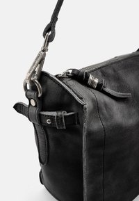 Borsa in pelle nera con superficie testurizzata, chiusura a zip e accessori in metallo. Include tracolle regolabili e dettagli in pelle.