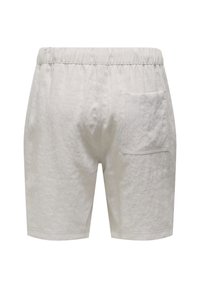 Helle beige Baumwollshorts mit einem elastischen Bund und einer einzelnen Gesäßtasche, ausgestattet mit einer zerknitterten Textur und geradem Schnitt.