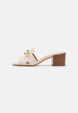 Mule beige à bout ouvert avec deux brides, détail boucle dorée et talon carré en bois.