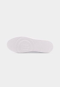 Semelle de chaussure blanche avec motif de grip circulaire texturé et petits points en relief couvrant toute la surface.