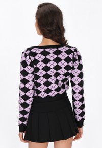 Čierny a levanduľový sveter s argyle vzorom, dlhé rukávy a rebrovaný lem, skombinovaný s plisovanou čiernou mini sukňou.