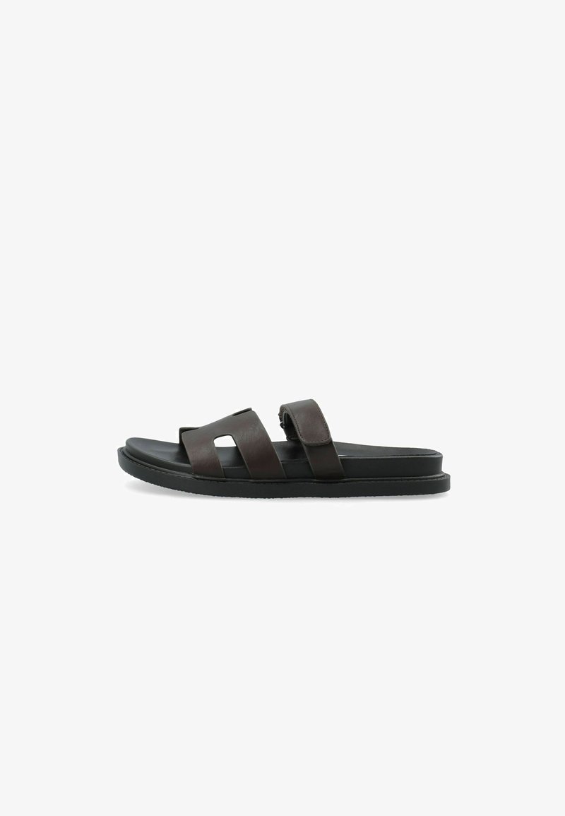 Sandale mule en cuir marron foncé avec deux larges brides et une semelle plate noire sur fond blanc.