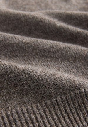 Grauer Strickstoff mit einer weichen Textur und einem subtilen, gerippten Muster. Das Material wirkt warm und eignet sich für gemütliche Kleidungsstücke.