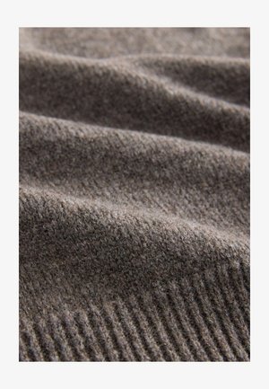 Szürke kötött anyag puha textúrával és finom, bordás mintázattal. Az anyag melegnek tűnik, és alkalmas kényelmes ruhadarabokhoz.