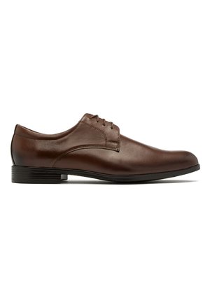 Brązowe skórzane buty eleganckie o gładkim wykończeniu, niskim profilu, zaokrąglonym nosku i wiązanym designie. Podeszwa jest płaska i lekko teksturowana.