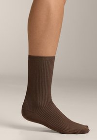Barna bordázott zokni, közép-szárú kialakítással, texturált anyagból, kényelmet és stabilitást biztosító szoros szegéllyel.