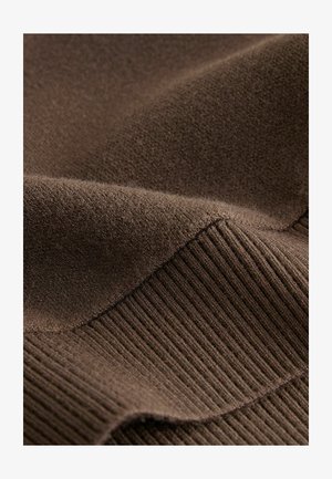 Brązowa tkanina o miękkiej teksturze i żebrowanym wzorze wzdłuż krawędzi, z gładkimi, lekko puszystymi fragmentami.