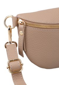 Beige leren schoudertas met een gestructureerde afwerking, gouden metalen rits en hardware, geaccentueerd door een verstelbare schouderband en drukknoopdetail.