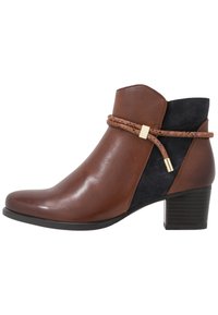 Bottine en cuir marron avec un panneau en daim noir, détaillée d'une sangle marron texturée et de ferrures dorées. Talon bloc.