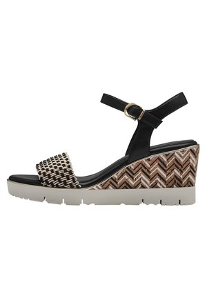 Sandale à talon noir avec une bride tissée noire et dorée, plateforme texturée à motif chevron en marron et blanc, semelle en caoutchouc.