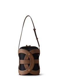 Structured cylindrical bag in black fabric with brown textured leather accents. Features cross-body strap and distinctive cut-out design.