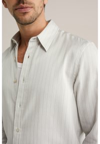 Hellgraues Hemd mit Knopfleiste und vertikalen Streifen, aus weichem Stoff gefertigt. Verfügt über einen klassischen Kragen und dezente Knopfakzente.