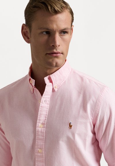 Camisa de botão riscada em rosa claro, feita de algodão, com colarinho clássico e pequeno logótipo bordado no peito.