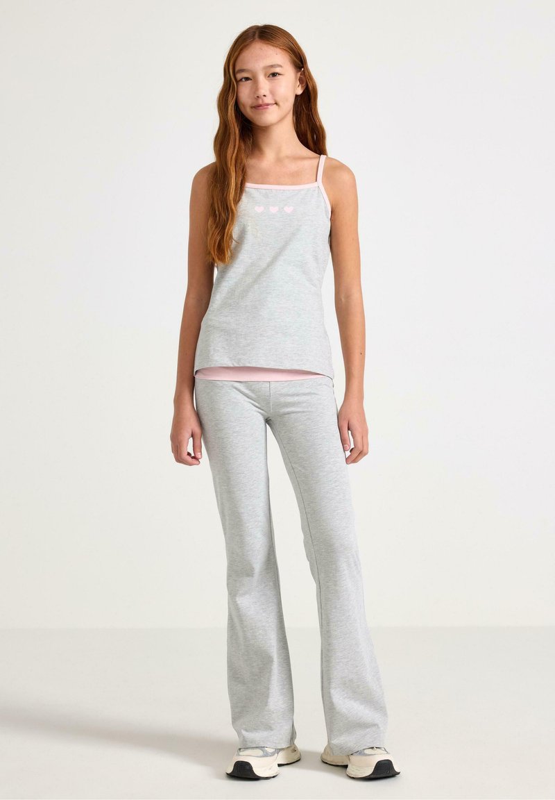 Szary bawełniany top na ramiączkach z cienkimi paskami, ozdobiony jasnoróżowymi nadrukami serc, zestawiony z dopasowanymi szarymi rozszerzanymi spodniami, oba z miękkiego, wygodnego materiału.