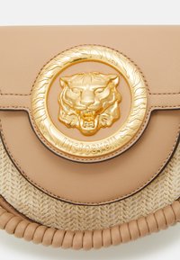 Borsa in pelle color cuoio con emblematico tondo dorato a forma di tigre con dettagli in rilievo, base in paglia intrecciata e bordatura in pelle intrecciata.