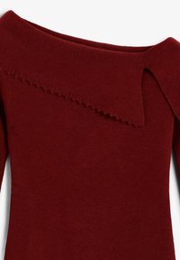 Suéter de punto rojo con diseño de hombros descubiertos, escote con borde ondulado y tela suave y texturizada. Incluye mangas largas.