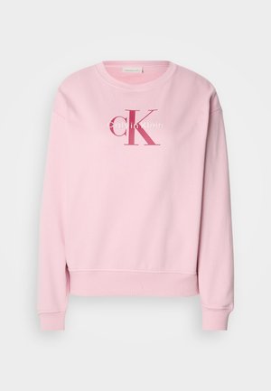 Roze sweatshirt met een ronde hals, lange mouwen en een logo op de voorkant met de tekst "Calvin Klein" en "cK" in contrasterende kleuren.