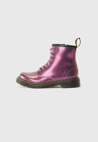 Stivali metallici viola con lacci, decorati con un motivo a pelle di serpente testurizzato, bordo nero alla caviglia e cuciture gialle lungo la suola.