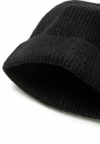 Bonnet en tricot noir en laine avec une texture côtelée, doté d'un revers replié et d'un sommet légèrement tombant.