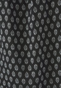 Schwarzer Stoff mit einem sich wiederholenden weißen Blumenmuster, das über feine Details verfügt. Die Textur wirkt glatt und leicht gewebt.