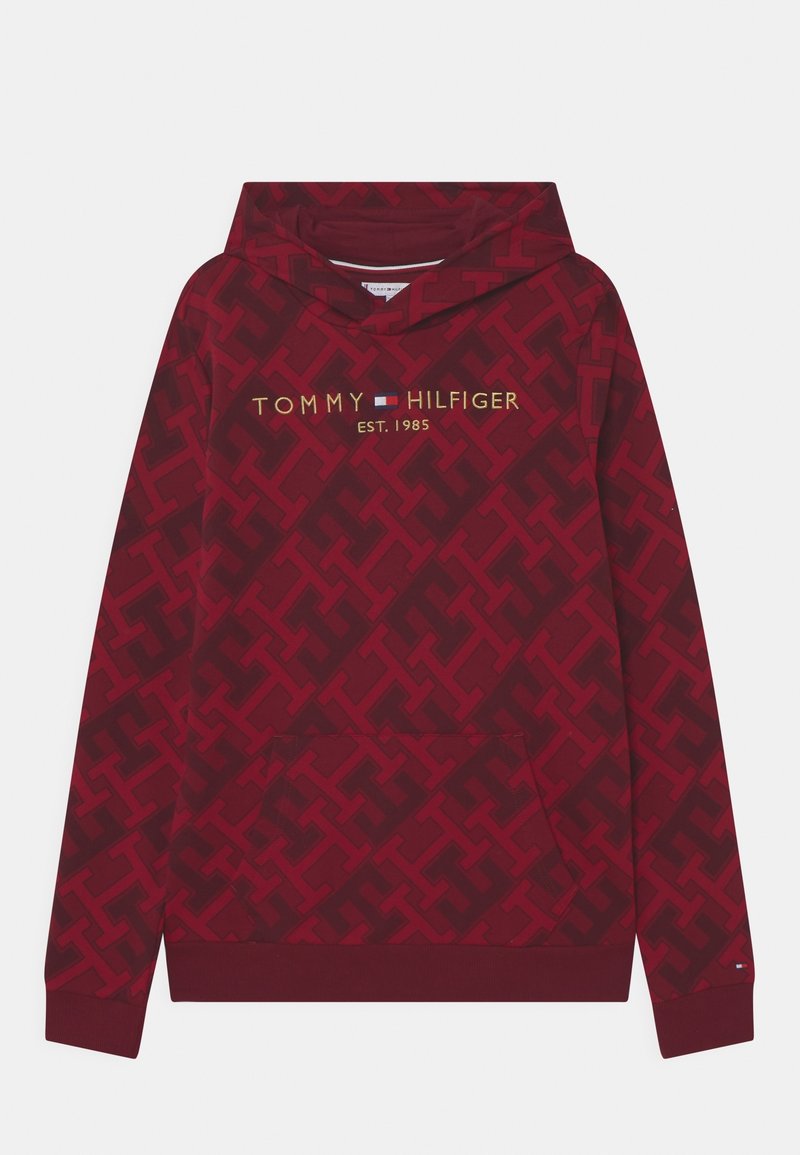 Red hoodie featuring a tonal logo pattern, pouch pocket, and “TOMMY HILFIGER” branding in gold. Ribbed cuffs and hem. Soft fabric texture.