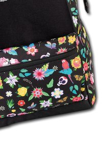 Sac à dos en tissu noir avec un imprimé floral et animal coloré, comprenant des crânes et des papillons, avec une poche zippée pour le rangement.