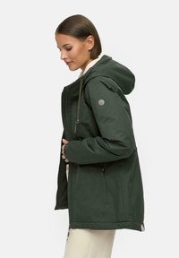 Green hooded jacket with zip closure, elastic cuffs, and drawstring hem. Features logo patch on sleeve and two side pockets.