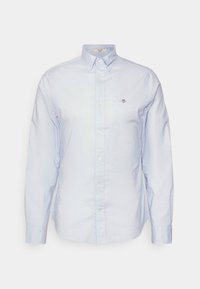 Chemise bleu clair à manches longues avec boutons, col boutonné et petit logo brodé sur la poitrine gauche.