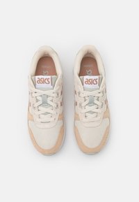 Lätta sneakers i kräm och mjuk persika, med en mesh-överdel, mockadetaljer och grå snören. ASICS-logotyp på tungan.