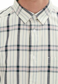 Camisa de botones con un patrón de cuadros de colores claros, con rayas alternas delgadas y gruesas en azul, gris y rosa suave, de tela de algodón.