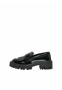 Mocassins en cuir verni noir avec une semelle épaisse, ornés de clous décoratifs et d'un détail de bandoulière frangée. Texture lisse et design élégant.