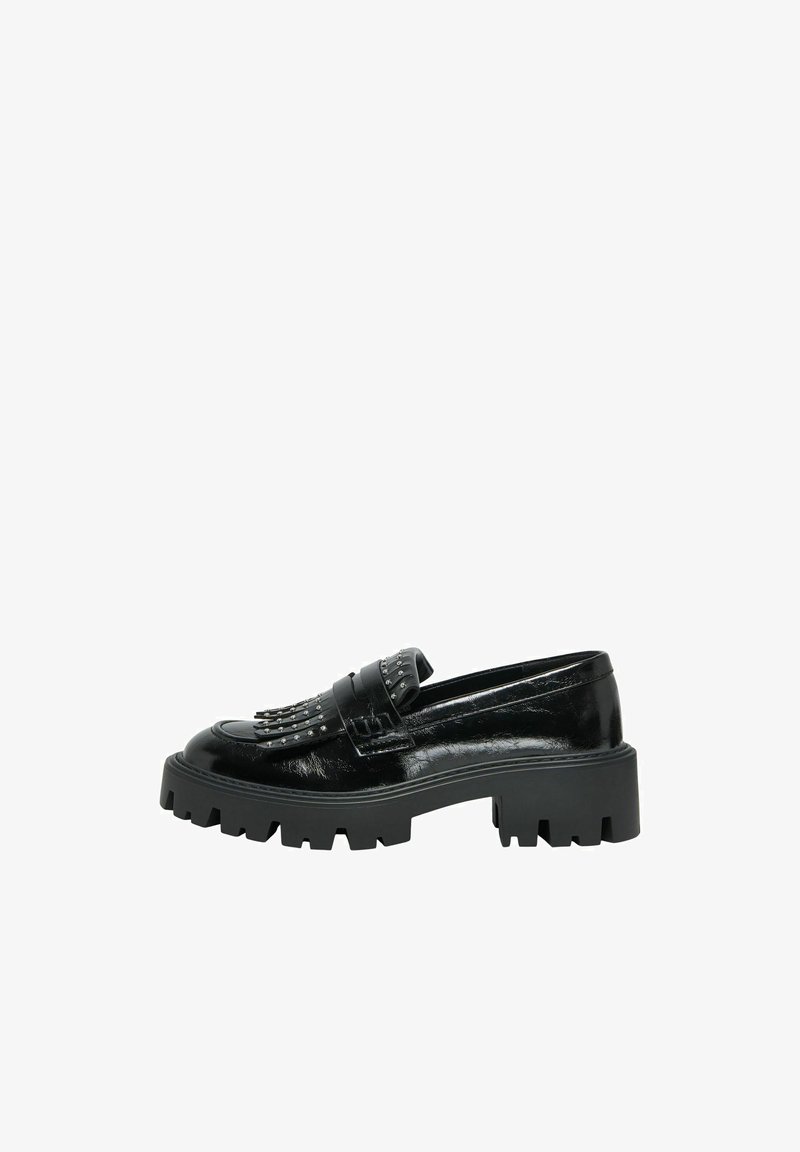 Mocassins en cuir verni noir avec une semelle épaisse, ornés de clous décoratifs et d'un détail de bandoulière frangée. Texture lisse et design élégant.