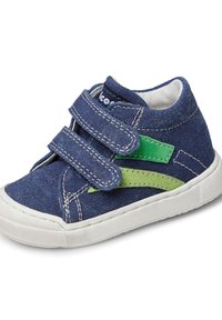 Sneaker in denim con tessuto blu, accenti verdi e suola in gomma bianca. Caratterizzato da due fasce in Velcro e cuciture a contrasto. Elementi di design curvi notevoli.