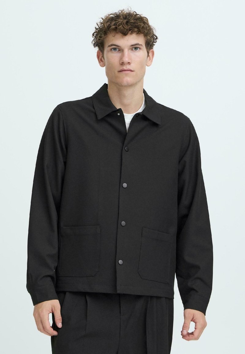 Black button-up jacket with a collar, two patch pockets, and a relaxed fit. Made of smooth fabric with a plain texture.