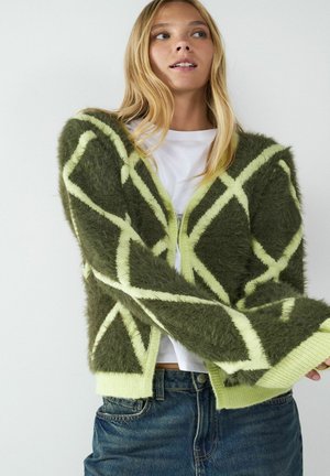 Flauschige grüne Strickjacke mit einem Rautenmuster in leuchtendem Gelb. Hat einen tiefen V-Ausschnitt, gerippte Bündchen und ein offenes Design.