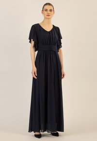 Marineblaues Maxikleid mit schwingenden Ärmeln, gerafftem Taillenbereich und fließendem Stoff. Glatte Textur mit V-Ausschnitt und langem Rock.