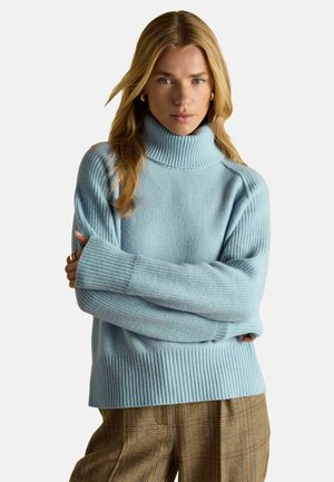 Hellblaues Rollkragensweatshirt aus weichem, strukturiertem Strick mit gerippten Details an den Bündchen und am Saum. Langer, entspannter Schnitt mit überschnittenen Schultern.