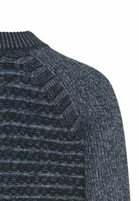 Sweter dziergany z teksturowanym wzorem w ciemnoniebieskim kolorze, z prążkowanymi mankietami i kołnierzem. Materiał wydaje się miękki i przytulny, odpowiedni do noszenia na co dzień.