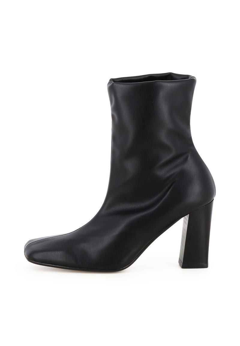 Schwarze Ankle-Boots aus glattem Leder, mit einer engen Passform, spitzem Zehenbereich und einem quadratischen hohen Absatz. Ungefähr 10 cm hoch.
