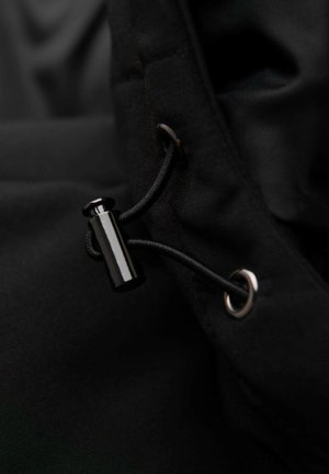 Černá látka s utahovacím šněrováním a lesklou černou brzdičkou a stříbrnou očkem, která zdůrazňuje hladký, texturovaný povrch.