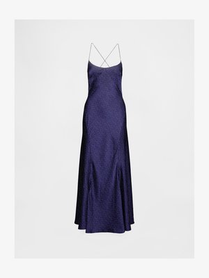 Robe longue en satin violet avec de fines bretelles croisées, présentant un motif à pois et une jupe évasée. Texture lisse et design fluide.