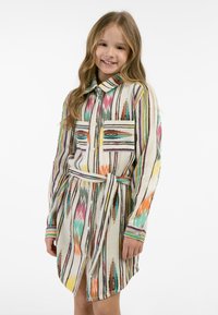 Abito camicia con colletto in tessuto leggero, caratterizzato da righe e motivi multicolori. Presenta tasche frontali e una vita legata. Chiusura con bottoni visibile.