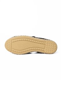 Podeszwa buta, z fakturowaną gumową powierzchnią o wzorze antypoślizgowym, w kolorze beżowym, z czarną tekstylną górną krawędzią.